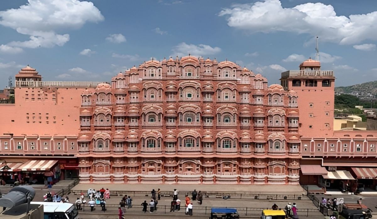 Hawa Mahal pink façade with 953 jharokhas and street activity below, part of the Golden Triangle India Tour.